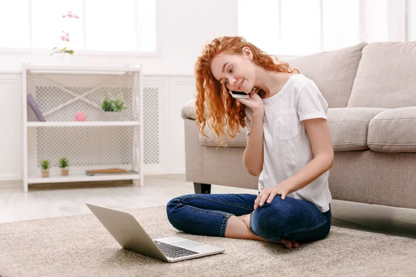 Mädchen mit Laptop und Handy sitzt auf dem Boden. — Stockfoto