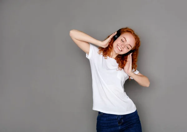 Žena poslouchat hudbu do sluchátek, studio zastřelil — Stock fotografie