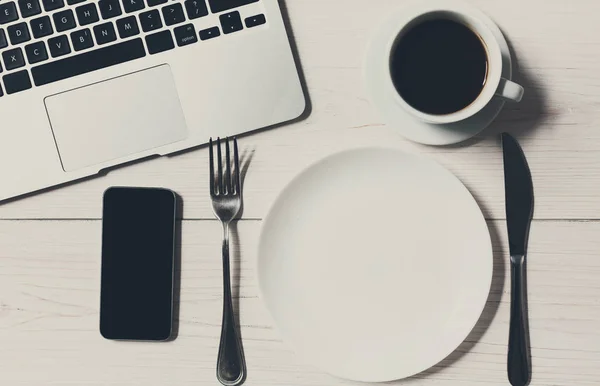 Концепция бизнеса или диеты, рабочее место с ноутбуком и пустой тарелкой — стоковое фото