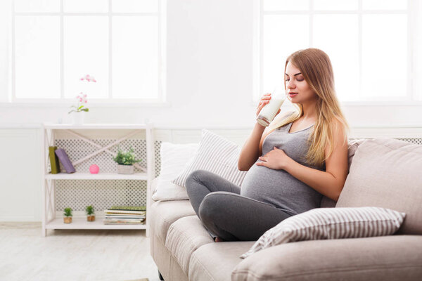 Pregnant woman drinking glass of milk