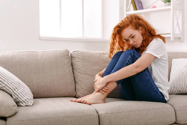 悲伤的红发女人想在米色的沙发上 — 图库照片