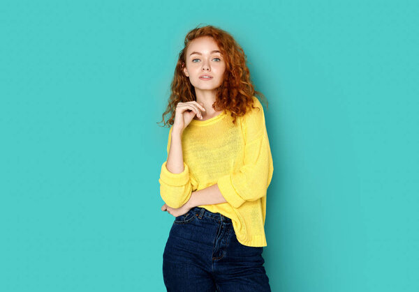 Cheerful girl in casual clothes posing at studio