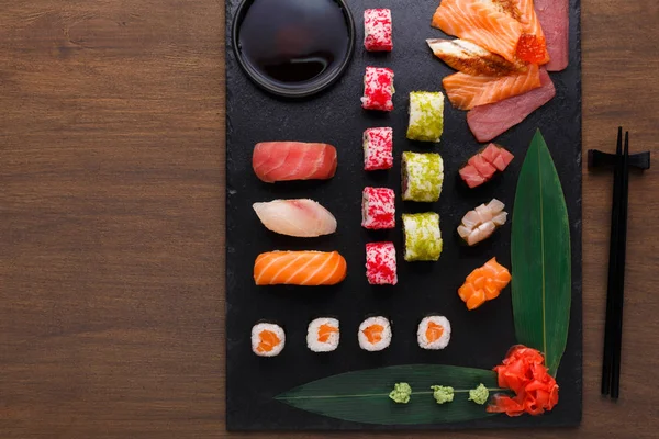 Sushi-maki és tekercs fekete rusztikus fa, top view — Stock Fotó