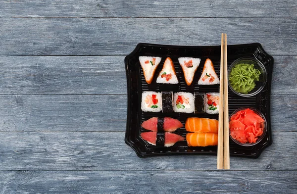 Japoński żywności dostawy. Zestaw sushi i rolkach widok z góry na drewno — Zdjęcie stockowe