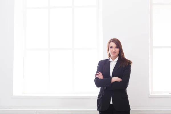 Успішна, красива бізнес-леді в офіційному костюмі стоїть в інтер'єрі білого офісу — стокове фото