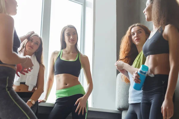 Young girls in sportswear chatting before yoga class