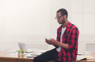 Genç işadamı cep telefonunuzda modern telefonla siyah