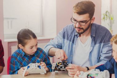 Eğitim kaynaklanıyor. Çocuklar robotlar öğretmen ile oluşturma