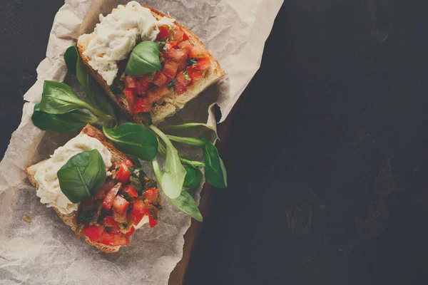 Bruschetta peynir ve siyah arka plan üzerine sebze ile