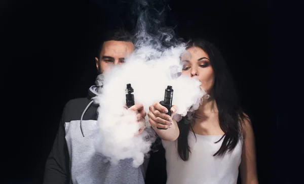 Casal jovem vaping e-cigarro com fumaça em close-up preto — Fotografia de Stock