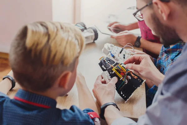 Stem education. Kids creating robots with teacher