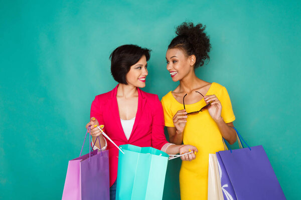 Excited multiethnic girls with shopping bags