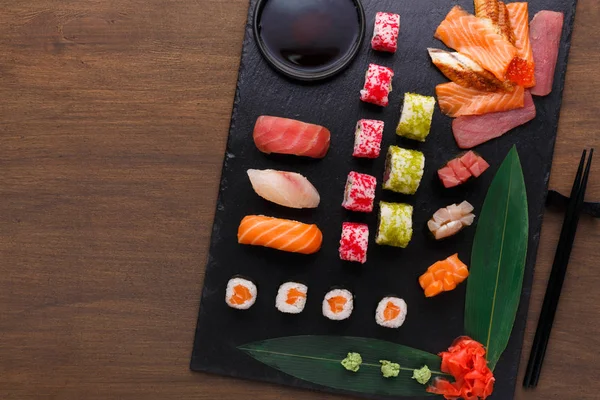 Sushi-maki és tekercs fekete rusztikus fa, top view — Stock Fotó