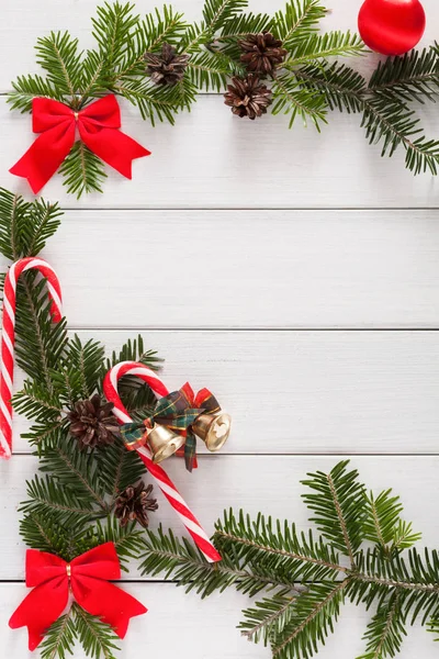 Sfondo natalizio con caramelle e bordo abete su legno — Foto Stock