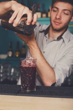 Genç barmen kokteyl içki cam içine dökme