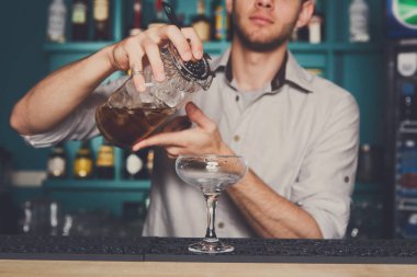 Genç barmen kokteyl içki cam içine dökme