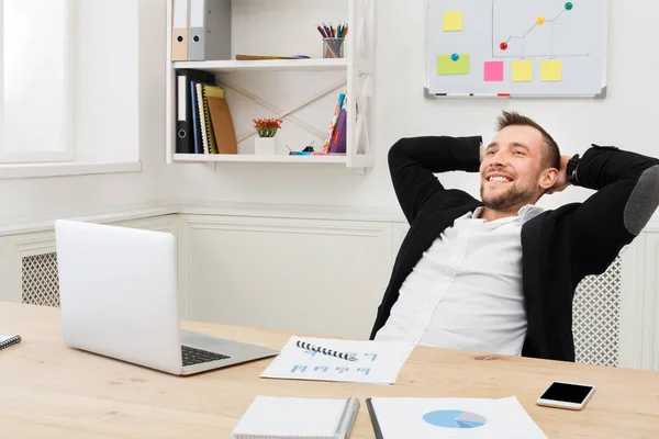 Jovem homem de negócios descontraído com laptop no escritório branco moderno — Fotografia de Stock