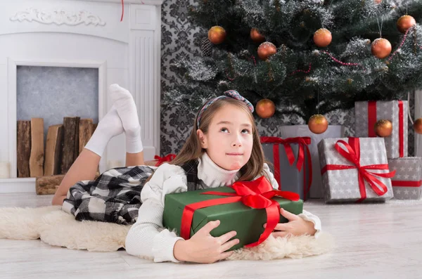 Hermosa niña y regalo de Navidad en el interior —  Fotos de Stock