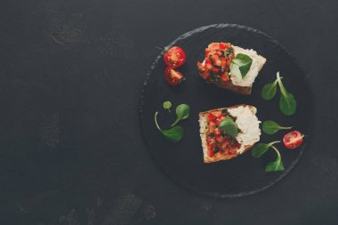 Bruschetta peynir ve siyah arka plan üzerine sebze ile