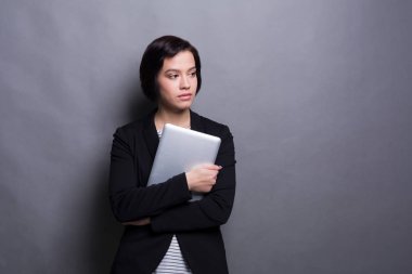 Tablet gri arka plan üzerinde ciddi kadınla