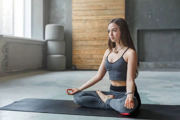 Mujer joven en clase de yoga, relajar la meditación pose —  Fotos de Stock