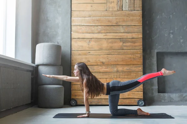 Mujer joven en clase de yoga haciendo ejercicio de estiramiento — Foto de Stock