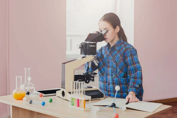 Estudante olhando em microscópio na lição — Fotografia de Stock