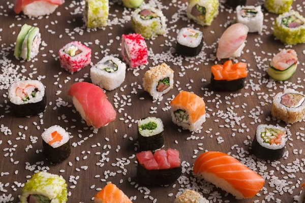 Set de sushi, maki y rollos con sésamo sobre fondo rústico de madera — Foto de Stock