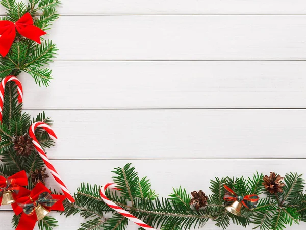 Weihnachten Hintergrund mit Bonbons und Tannenbaumrand auf Holz — Stockfoto
