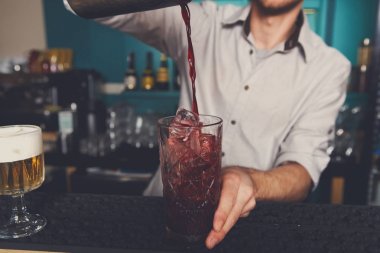 Genç barmen kokteyl içki cam içine dökme