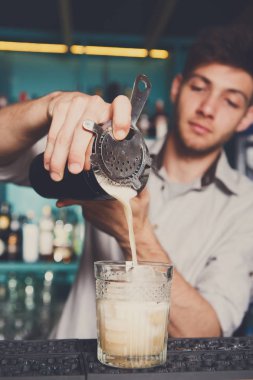 Genç barmen kokteyl içki cam içine dökme