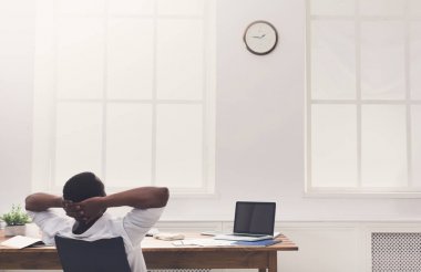 Modern beyaz ofis içinde laptop ile rahat siyah işadamı