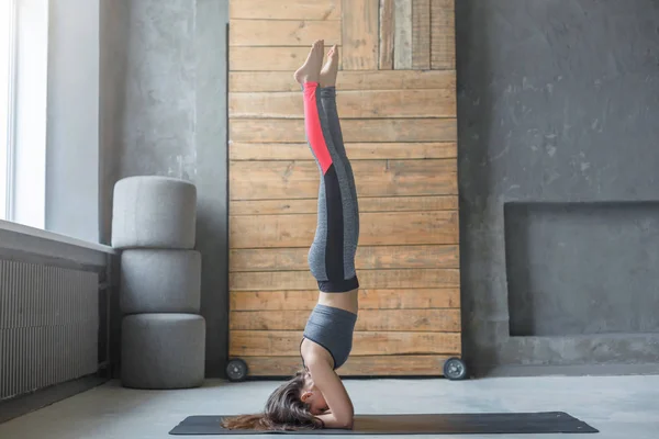 Mujer joven en clase de yoga haciendo cabecera — Foto de Stock