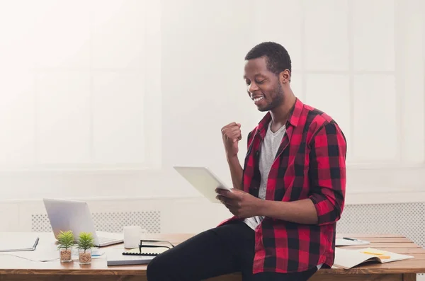 Щасливий чорний бізнесмен в сучасному офісі, робота з планшетом — стокове фото