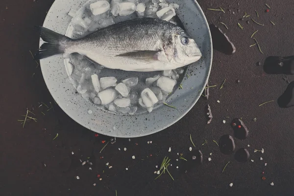 Dorado fresco en bandeja con hielo sobre fondo negro —  Fotos de Stock