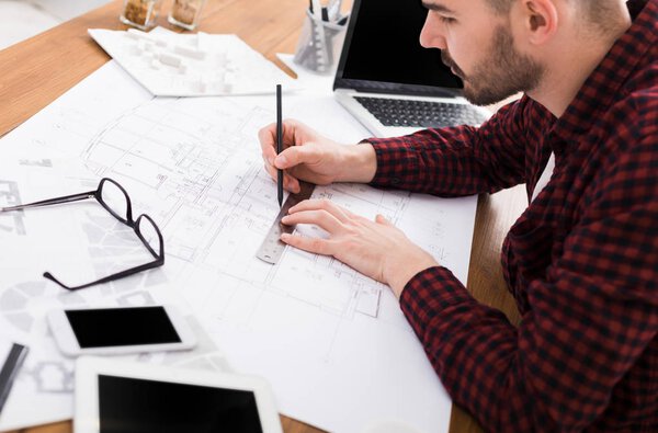 Architect working on blueprint in office