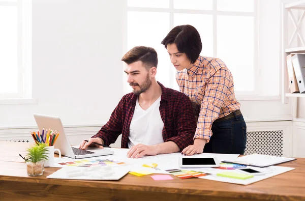 Couple of young designers working at modern office