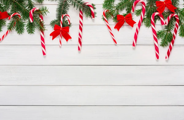 Christmas background with candies and fir tree border on wood — Stock Photo, Image