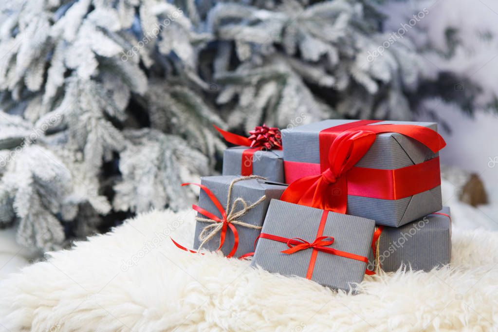 Christmas gifts on blurred fir tree background, holiday concept