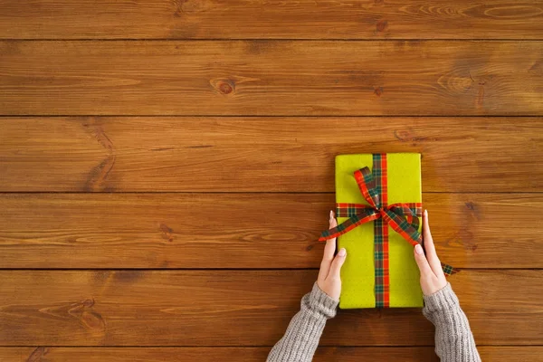Рождественский подарок на фоне коричневого дерева — стоковое фото