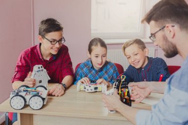 Eğitim kaynaklanıyor. Çocuklar robotlar öğretmen ile oluşturma