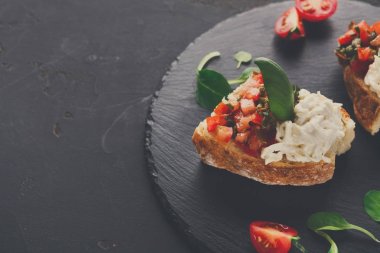 Bruschetta peynir ve siyah arka plan üzerine sebze ile