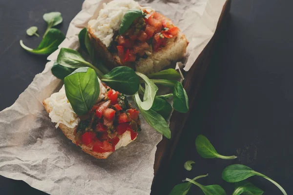 Bruschetta peynir ve siyah arka plan üzerine sebze ile — Stok fotoğraf