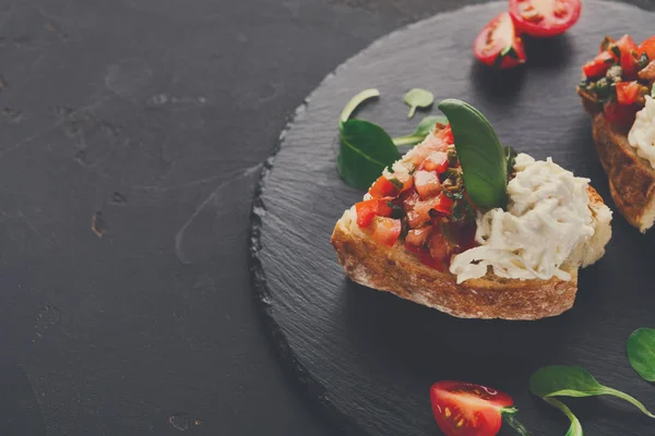 Bruschetta sajttal és zöldségekkel, fekete háttér — Stock Fotó