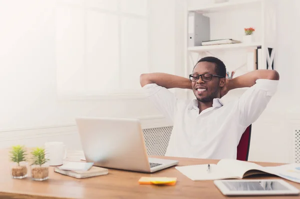 Relajado hombre de negocios negro con portátil en la oficina blanca moderna —  Fotos de Stock