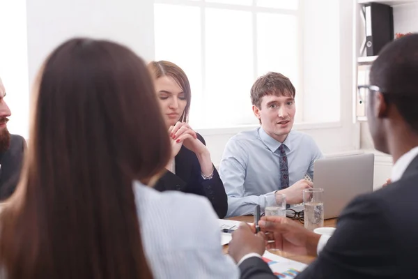 Reunión de negocios. Jóvenes empleados exitosos escuchan comentarios en el escritorio de la oficina — Foto de Stock