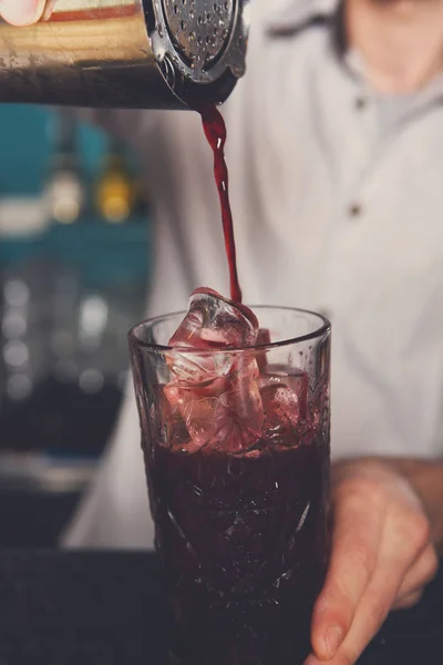 Jonge barman cocktail drinken in glas gieten — Stockfoto