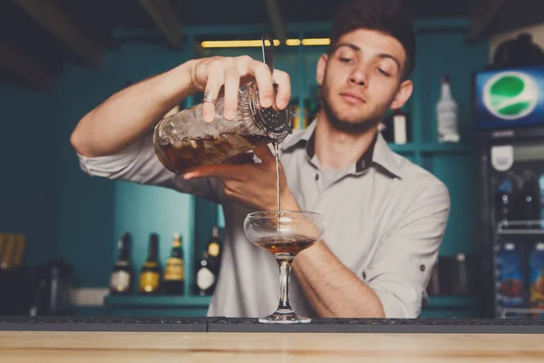 Genç barmen kokteyl içki cam içine dökme — Stok fotoğraf