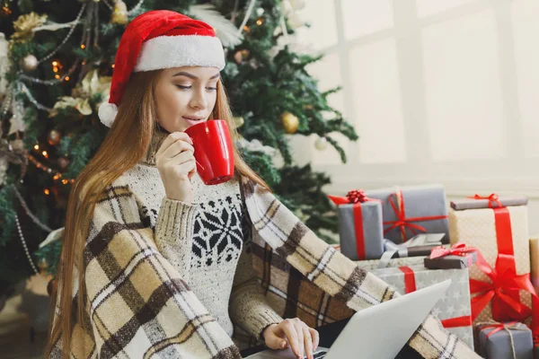 Młoda kobieta online na laptopie w Boże Narodzenie wnętrze — Zdjęcie stockowe