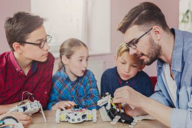 Eğitim kaynaklanıyor. Çocuklar robotlar öğretmen ile oluşturma